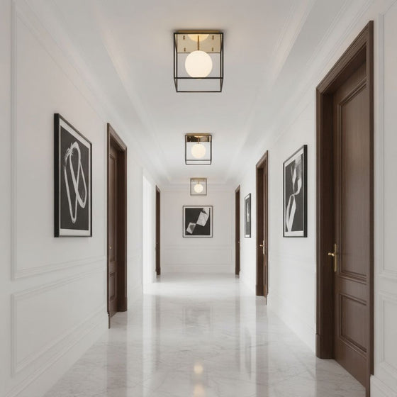 Modern hallway with white walls, wooden doors, and decorative lighting fixtures. Black with gold ceiling light with  frosted globe glass.