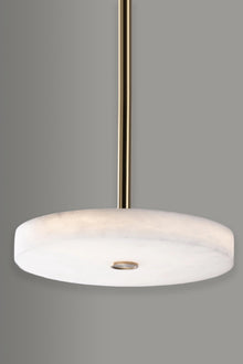  Modern alabaster pendant light with white shade and satin brass fixture on a gray background