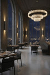 Luxurious restaurant interior with a large chandelier and cityscape view. Metal wall sconces.