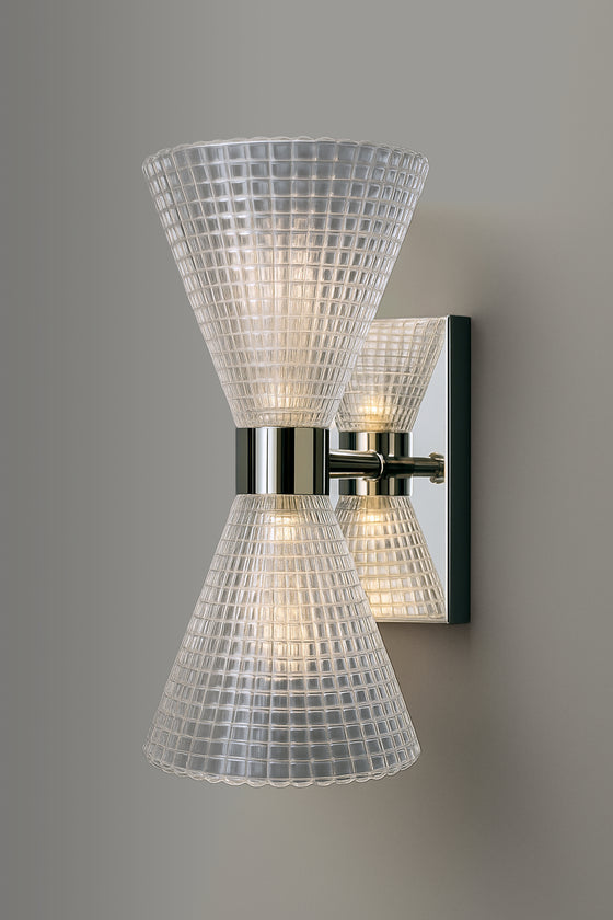 Wall-mounted polished stainless steel light fixture with glass shades on a gray background