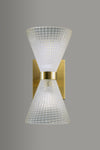 Wall-mounted light fixture with textured glass shade and satin brass base on a gray background