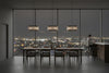 Modern dining room with a large window view of a city skyline at night. Satin brass pendant with clear glass.