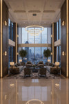 Luxurious lobby with modern furniture and large windows overlooking a cityscape. Glass LED sconce.