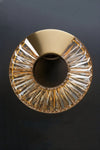 Decorative satin brass and crystal glass LED sconce on a dark background