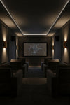 Dark home theater with a screen displaying two people, surrounded by comfortable seating. Gold Wall sconce, LED. 