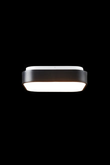  A contemporary square ceiling light fixture with a black matte finish and a visible LED lamp, set against a black background.