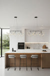 Modern kitchen with white island, bar stools, and hanging LED, matte black chandelier lights.