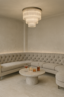  Modern living room with a curved sofa, round coffee table, and satin stainless steel with glass chandelier ceiling mount LED.