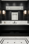 Modern bathroom with black tiles, white marble countertop, and decorative floor with matte black and frosted glass wall sconce.