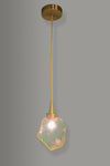 Modern pendant light with amber geometric glass shade and brass fixture on a gray background