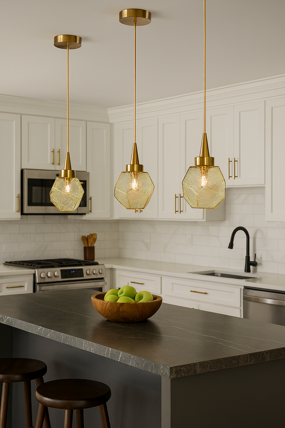 Modern kitchen with satin brass with amber glass pendant lights, white cabinets, and a bowl of apples on the counter.