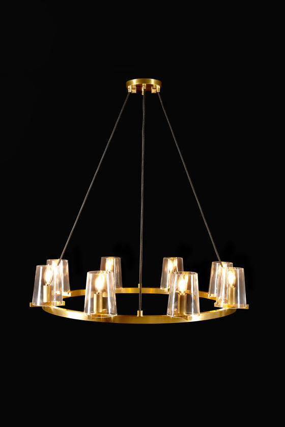 A chandelier with eight round glass shades and a satin brass body, hanging from the ceiling.