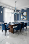 Dining room with blue chairs, a wooden table, and a blue glass chandelier.