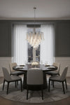 Dining room with round table and chairs under a modern silver frame with clear and white glass chandelier.