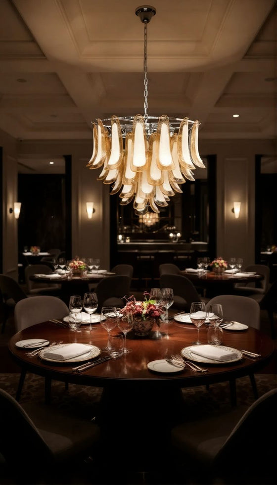 Dining room with a silver frame and amber and white glass chandelier, table setting, and decorative elements.