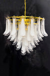 A mid century petal chandelier with clear and white glass accents and a gold frame, designed for ceiling mounting.