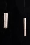 Two cylindrical pendant lights with a terrazzo pattern against a black background.