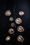 A mid-century modern style chandelier with geometric lines, featuring a gold finish and crackle glass globe lights.