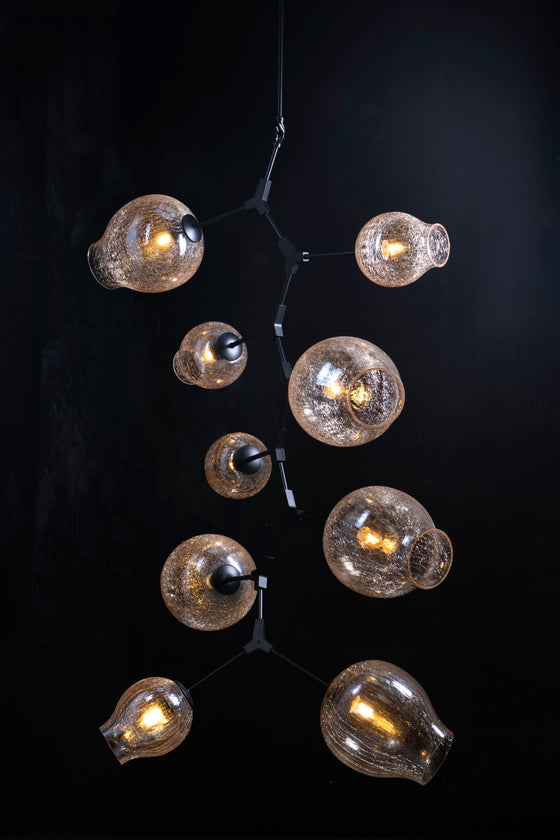 A mid-century modern style chandelier with geometric lines, featuring a gold finish and crackle glass globe lights.