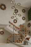 Decorative interior with wreaths, garlands, and pumpkins in a modern home setting. Satin brass with smoke glass chandelier pendant.