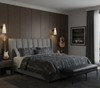 Modern bedroom with a bed, nightstands, and wall art and matte black with frosted glass sconces.