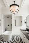 Modern bathroom with freestanding bathtub, vanity, and decorative faux linen chandelier lighting.