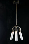 A modern bronze pendant light with three adjustable white glass bulbs, suspended from a ceiling by a metal chain.