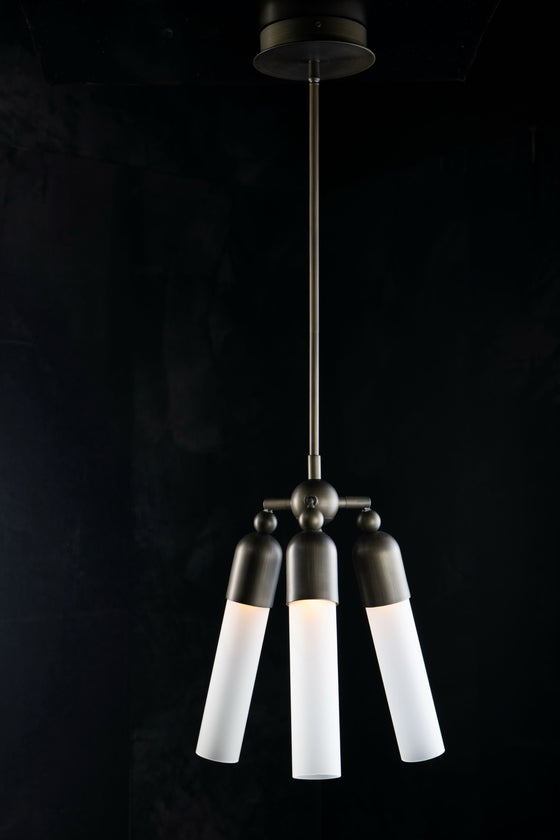 A modern bronze pendant light with three adjustable white glass bulbs, suspended from a ceiling by a metal chain.