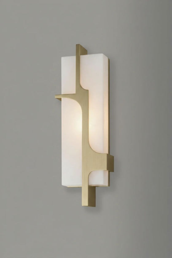 Modern alabaster wall sconce with satin brass frame and white glass on a gray background