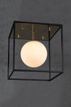 A contemporary style ceiling-mounted light fixture with a polished brass canopy and a matte black frame, featuring a white globe.