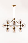 A sophisticated chandelier with a satin brass finish and smoke glass globes, suspended in a state of descent with multiple adjustable stems.