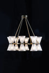 A contemporary glass chandelier with a satin brass finish, featuring multiple clear glass shades.
