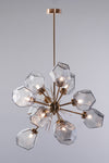 A contemporary style chandelier with a satin brass finish and geometric smoke glass geodes, creating a starburst pattern.
