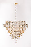 A satin brass chandelier with ribbed glass globes and brass metal rings, against a white background.