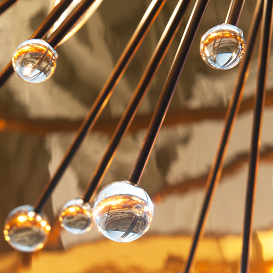 Detail view of the glass balls and the gold metallic interior of the shade of the Isla Chandelier