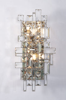  A wall sconce with a polished stainless steel finish, featuring a symmetrical shade layered with crystal baguettes.