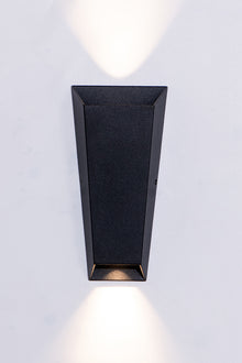  A modern black wall sconce with tapered body, casting light both up and down.