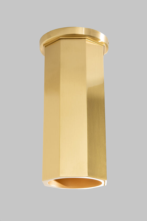 A satin brass Octavia downlight installed on a ceiling, with light shining down from its cylindrical metal shell.