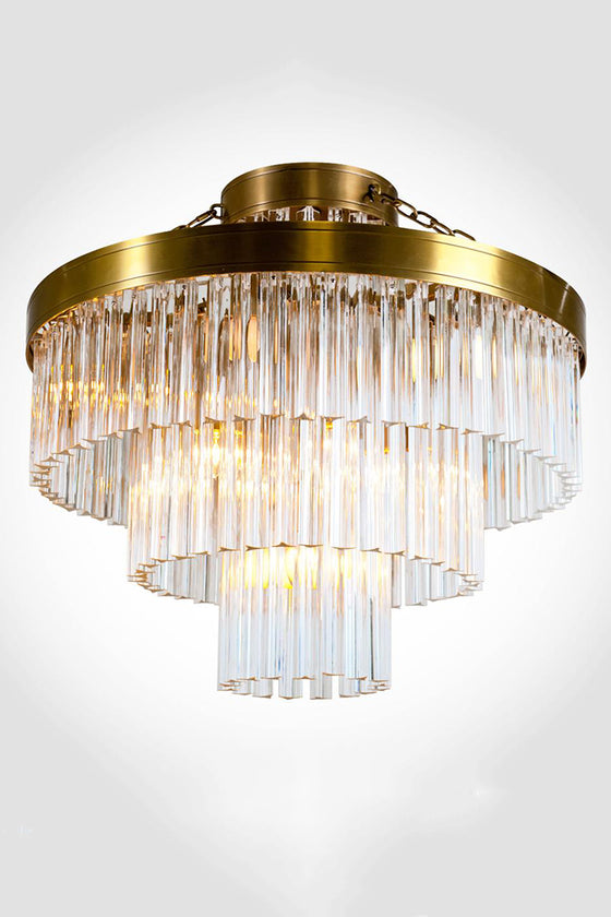 A satin brass geometric ceiling light fixture with clear glass prisms.